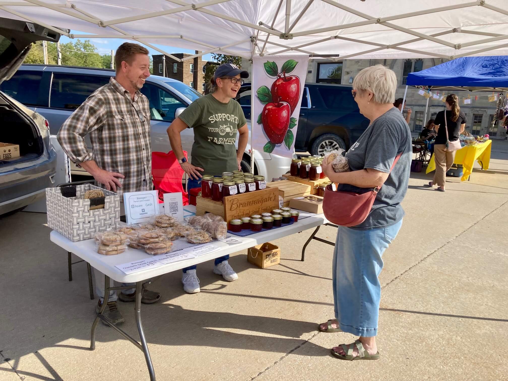 Vendors visiting with customer at Beatrice Farmers Market